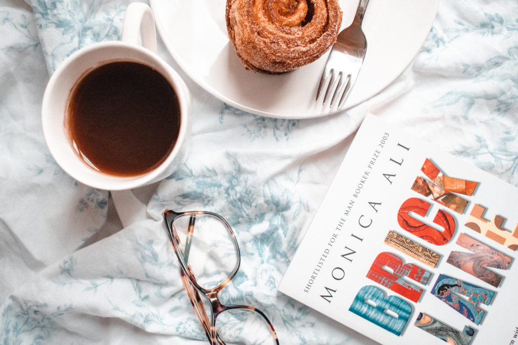 Literary London flat lay with coffee, pastry and Monica Ali's book, Brick Lane