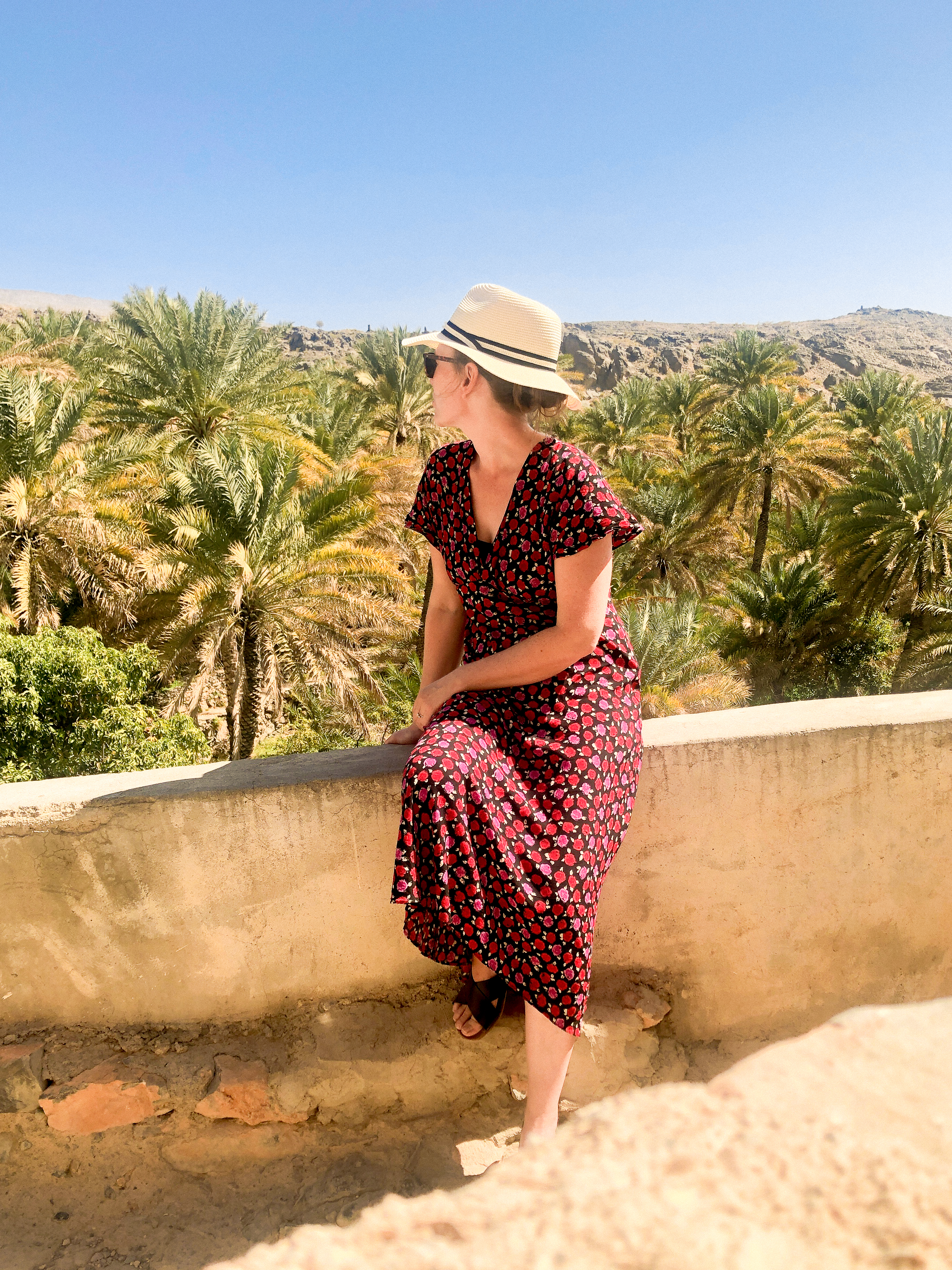 Woman looking out over palm grove in Misfat al Abriyyen
