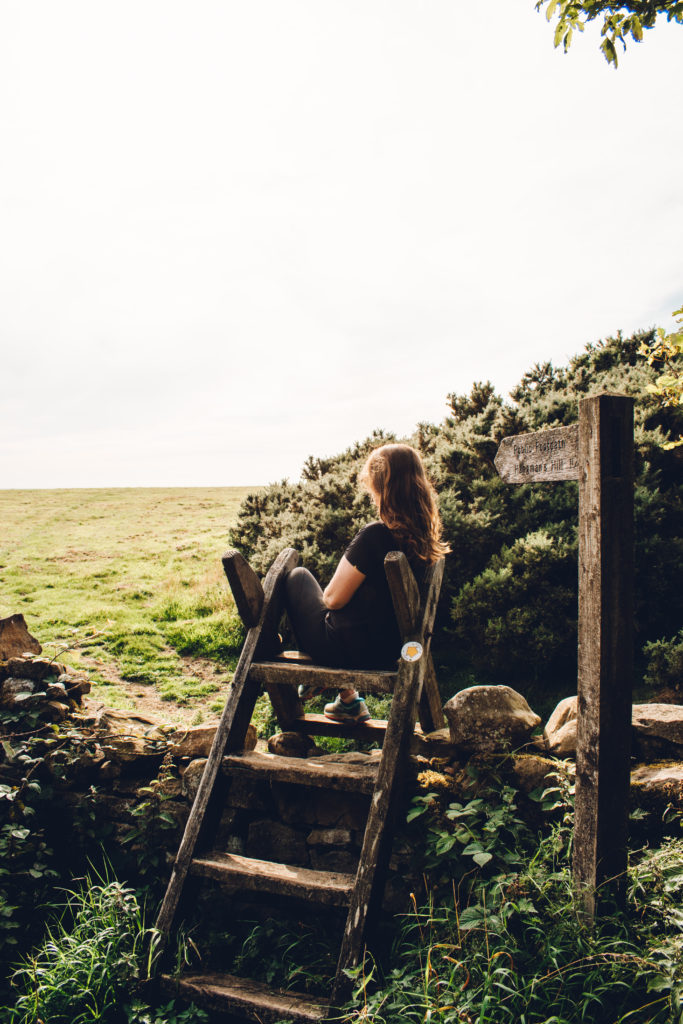 Woman sat on stile on Hadrian's Wall Path