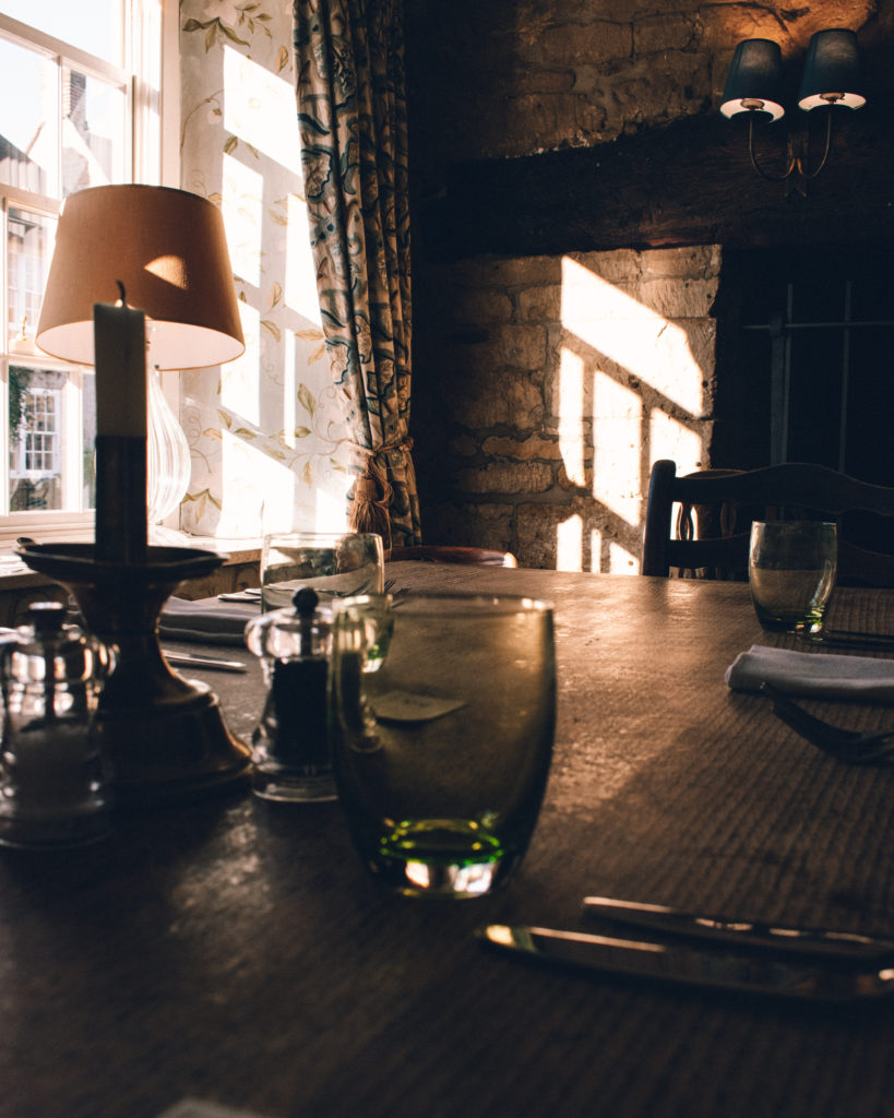 Pub table laid with cutlery in front of light filled window
