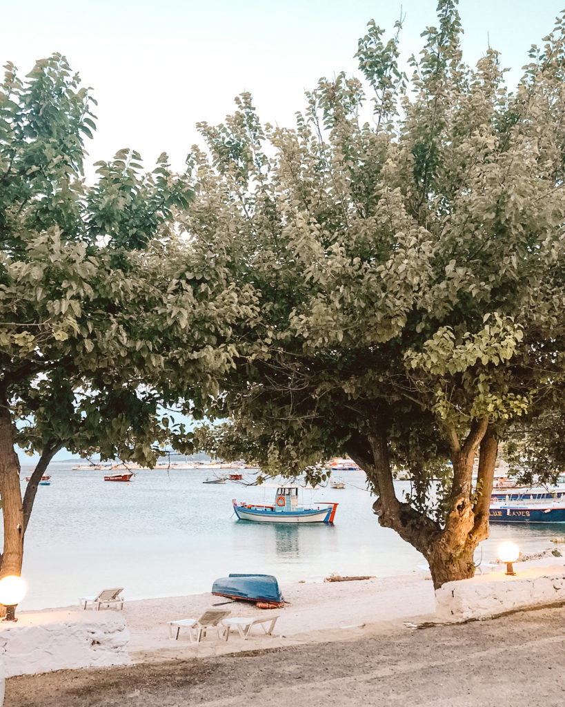 Dusk light on trees and fishing boats in Agios Nikolaos