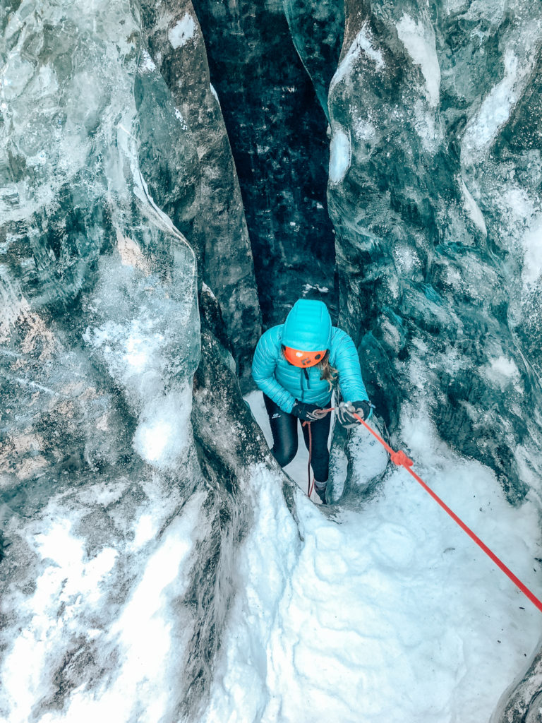 Woman climbing in crevice on Icelandic glacier