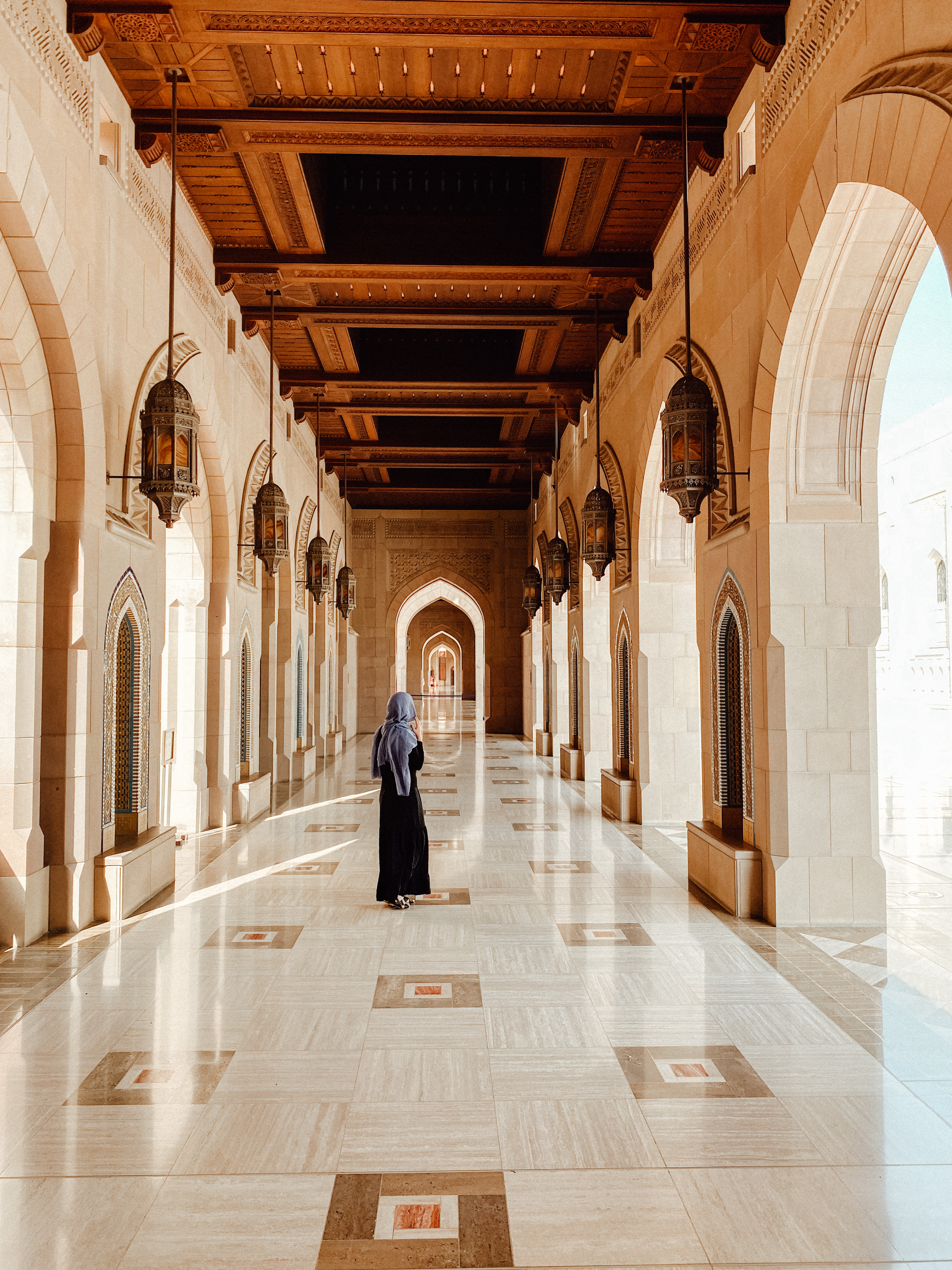Woman walking in the porticos of Sultan Qaboos Mosque