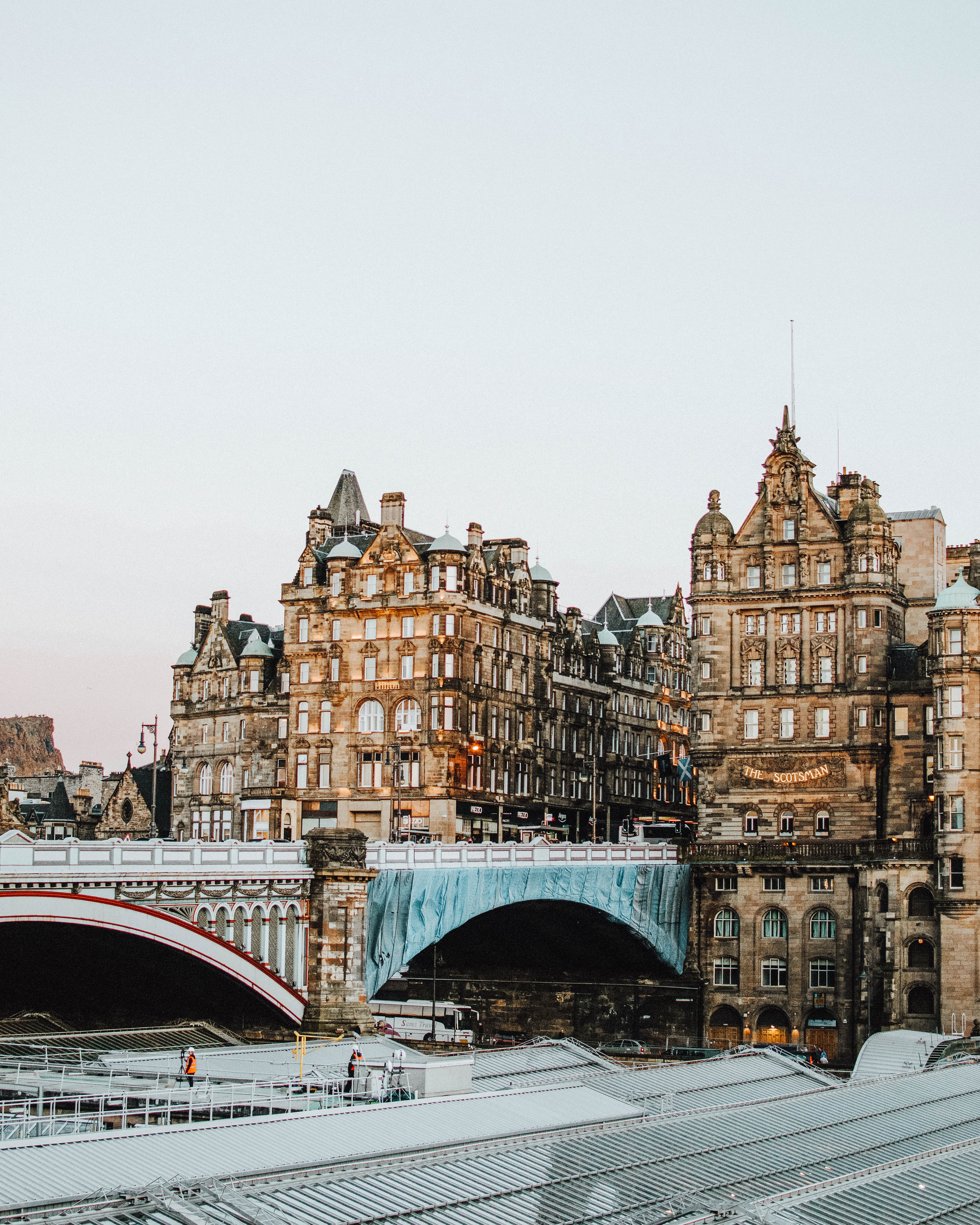 Glass roof of Waverley Train Station in front of traditional stone Edinburgh buildings