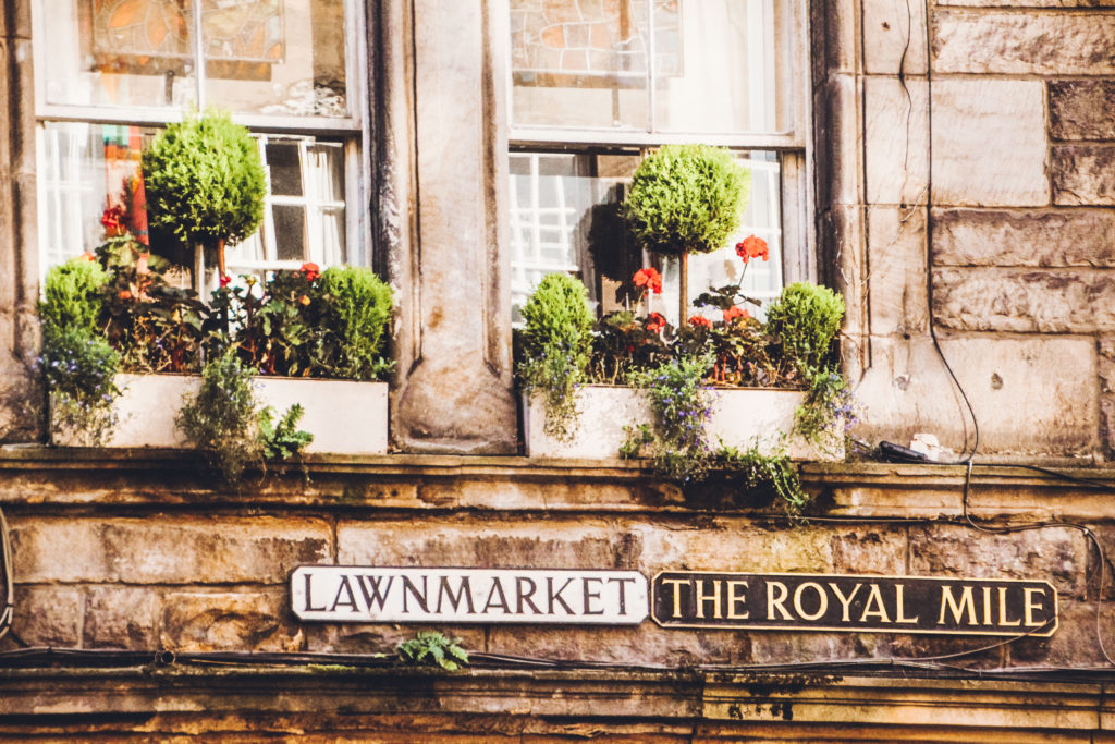 Royal Mile and Lawnmarket signs below colourful window boxes