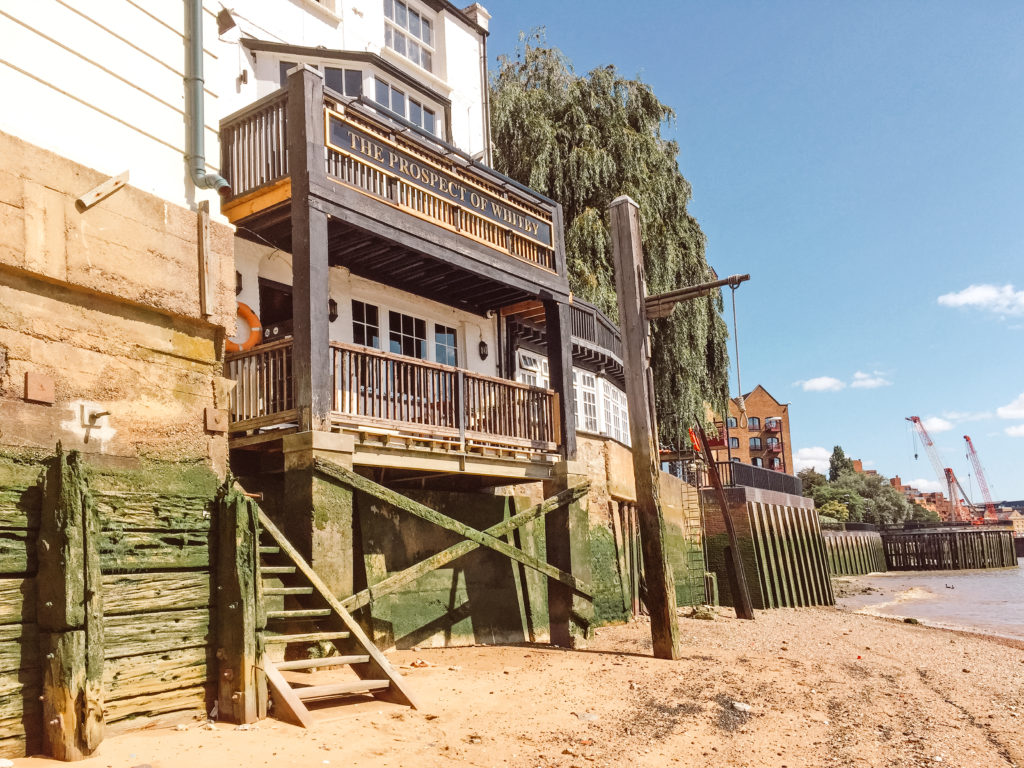 Wooden balconies of the Prospect of Whitby from the sandy edge of the Thames River