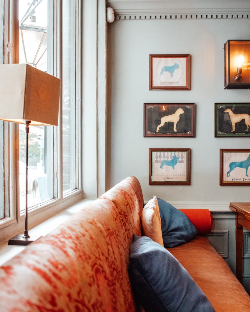 Red sofas and pictures of dogs on wall of London pub, Prince Albert Battersea