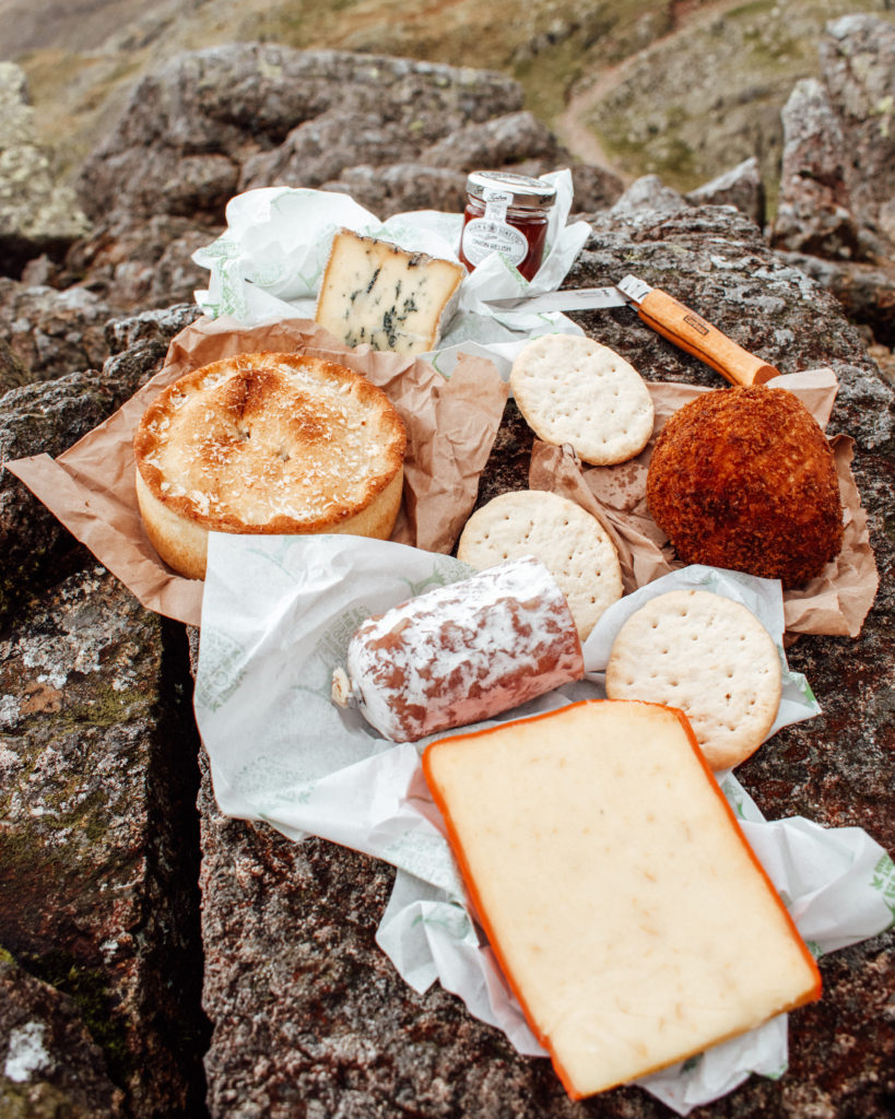 Picnic lunch of cheese and a vegetarian pie laid out on Crinkle Crags, Lake District