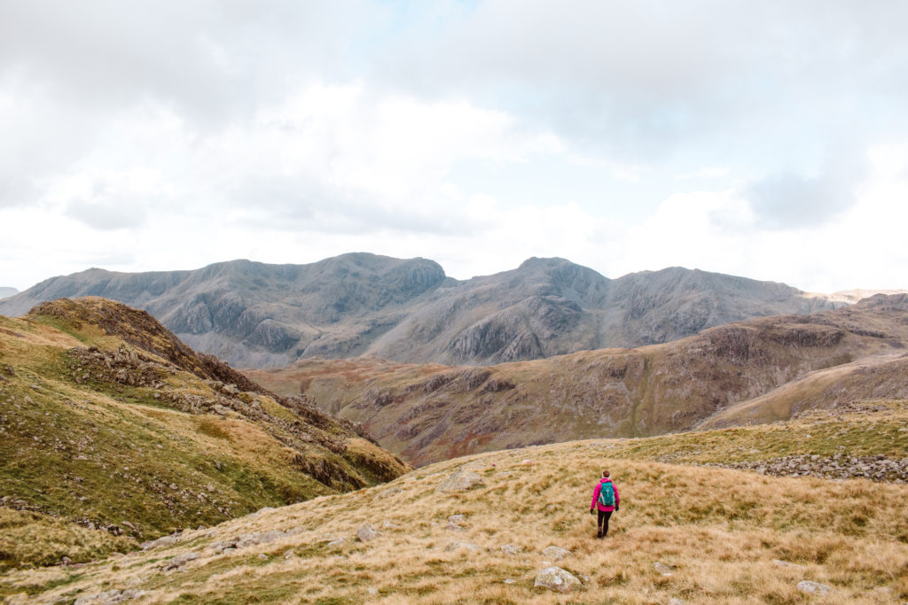 Woman hiking in Eskdale Valley, behind the Crinkle Crags
