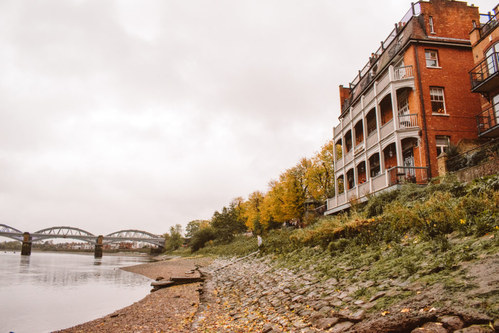 Red brick White Hart pub on edge of pebbly beach of River Thames