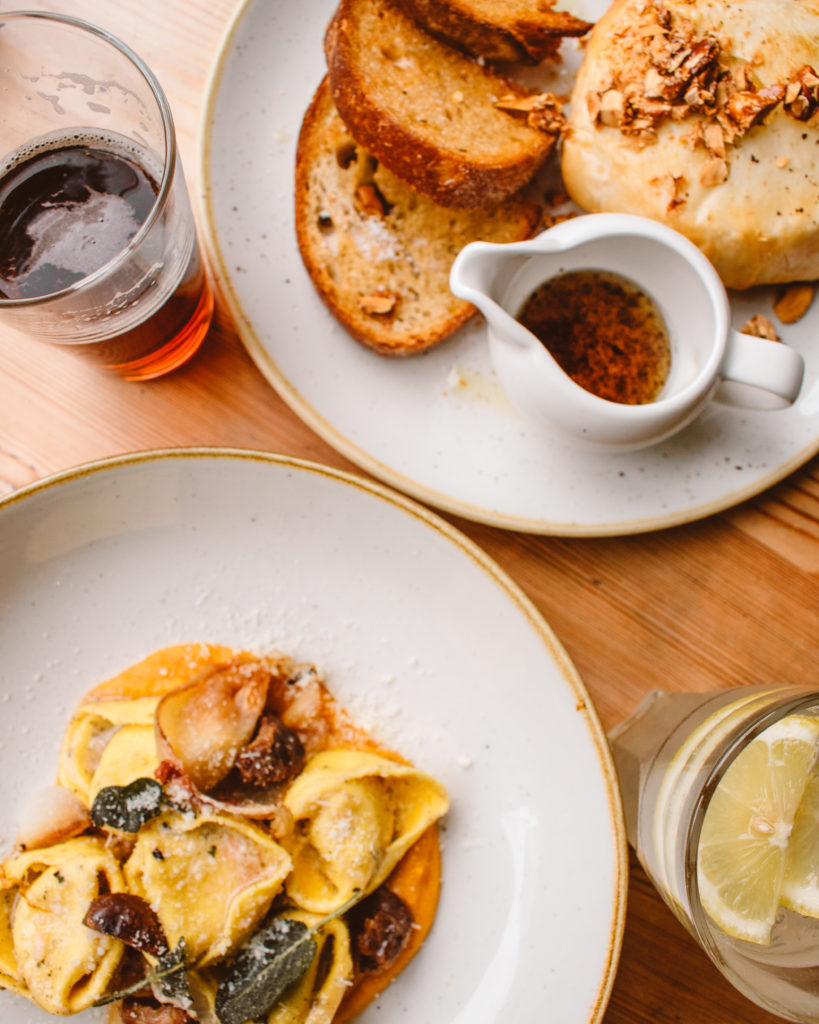 London Pubs flat lay - tortellini in a white bowls and baked Camembert at The Crabtree, Fulham  