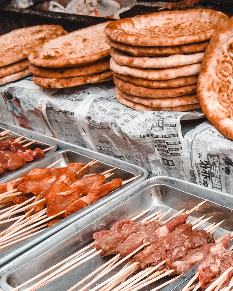 Meeat skewers in trays and decorated flat breads in Xi'An's Muslim Quarter