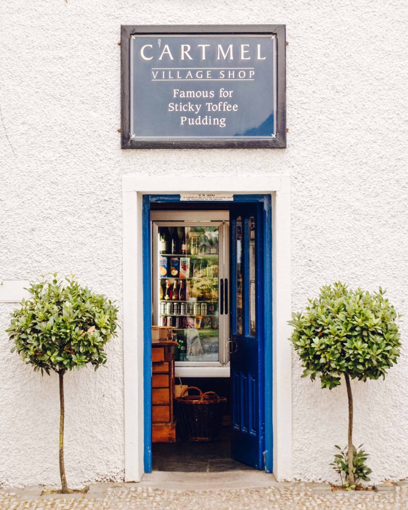 Lake District Foodie - Blue front door of Cartmel Village Shop between two potted plants