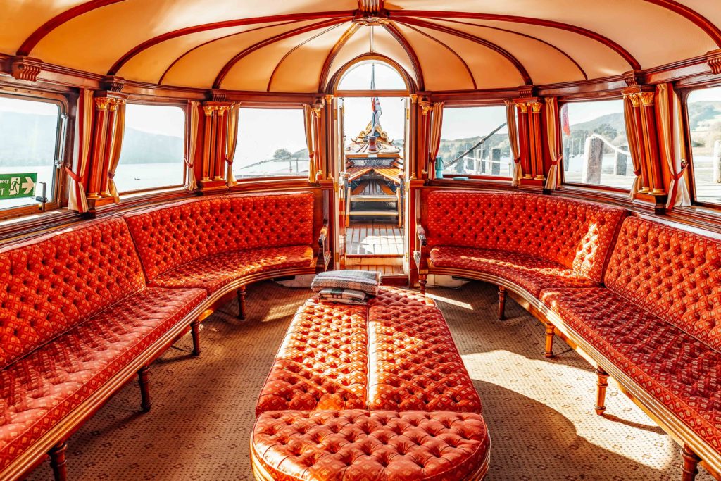 Red upholstered seats inside the restored yacht, The Gondola, on Coniston Water