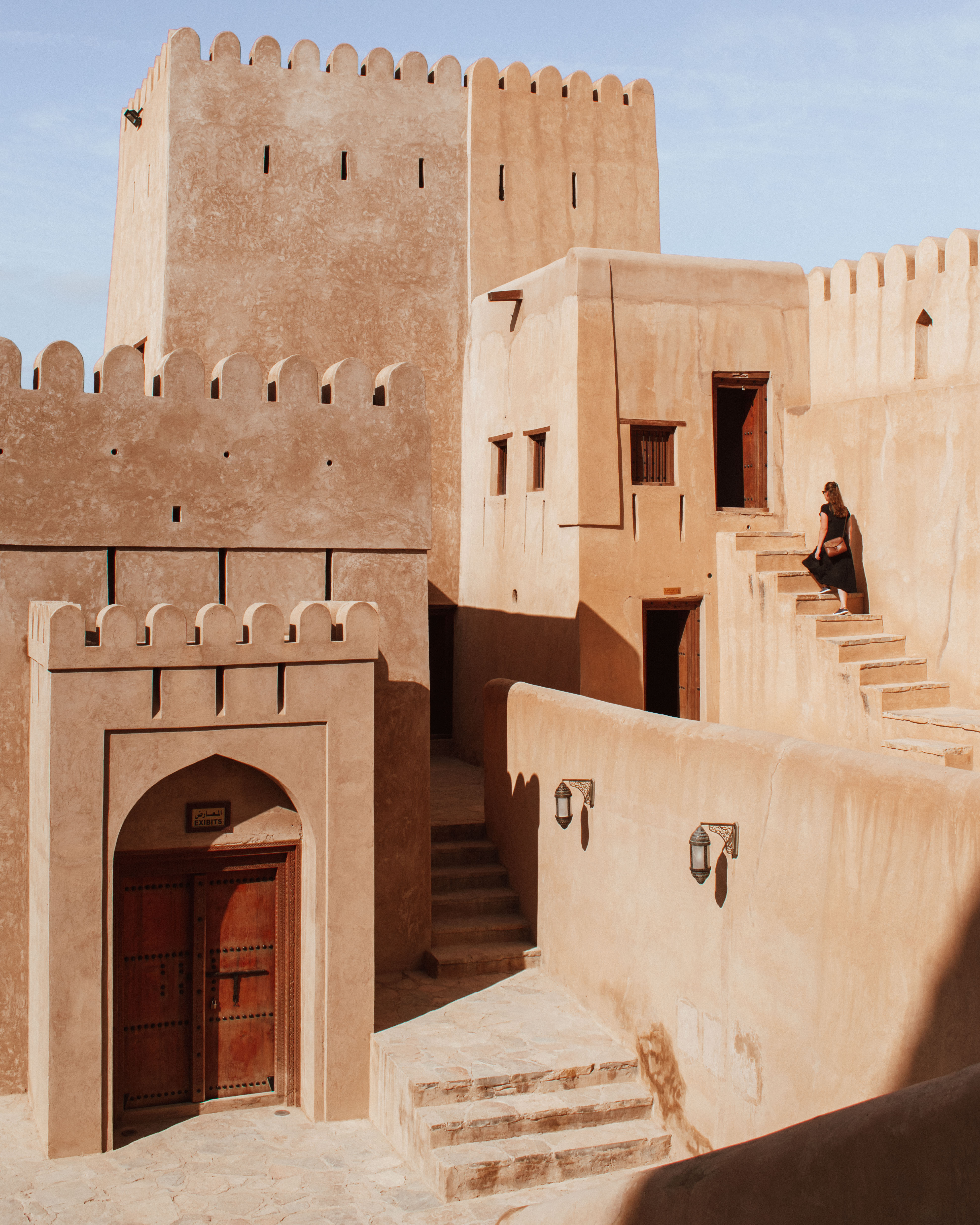 Woman climbing up steps in Nizwa Fort