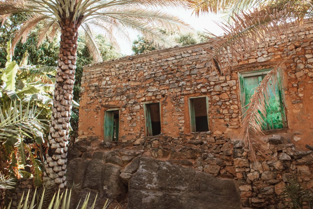 Old stone house with green shutters in Misfat Al Abriyeen