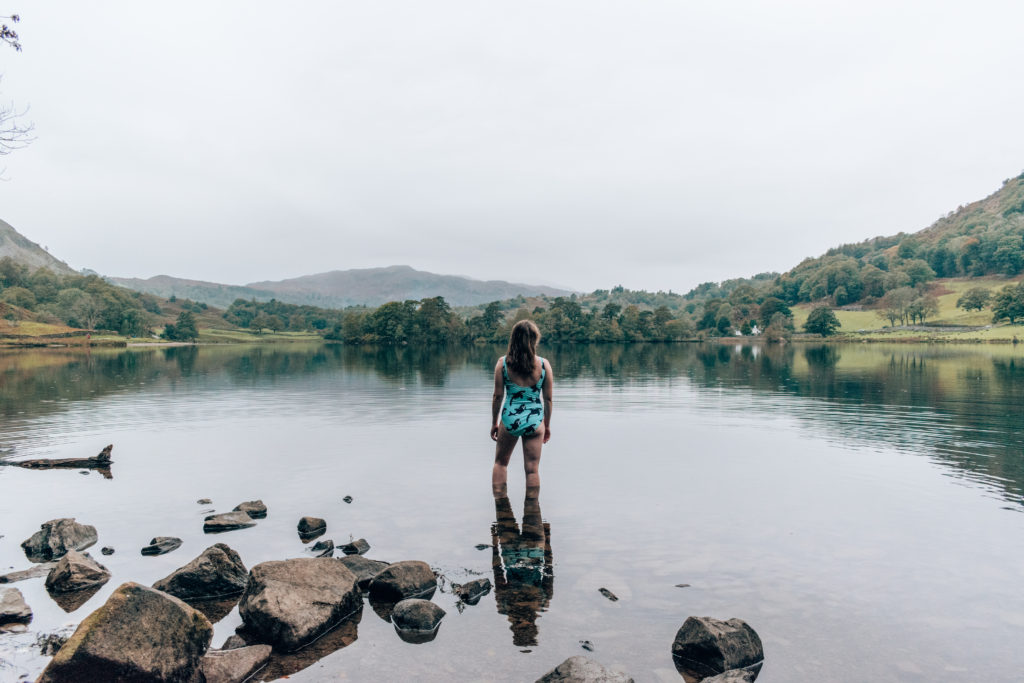 What to do in the Lakes on a rainy day: Woman in a blue swimming costume on a rainy day in Rydal Water
