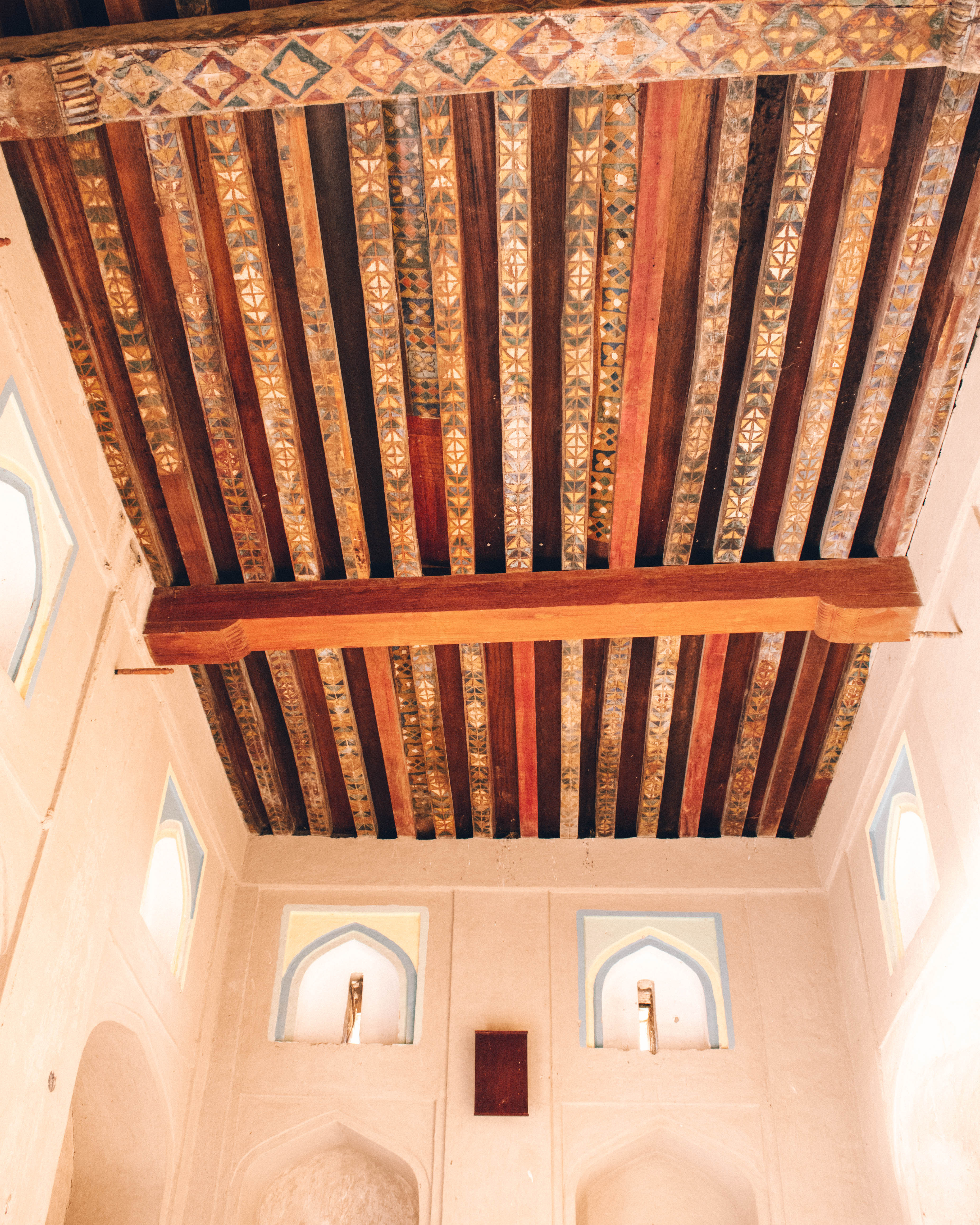 Intricately painted ceiling beams in Bahla Fort