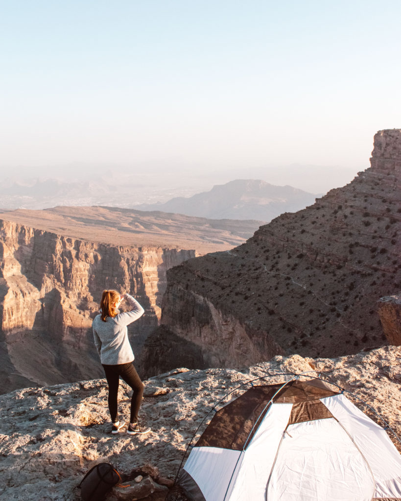 Woman next to a tent looking at view of Wadi Ghul, Jebel Shams