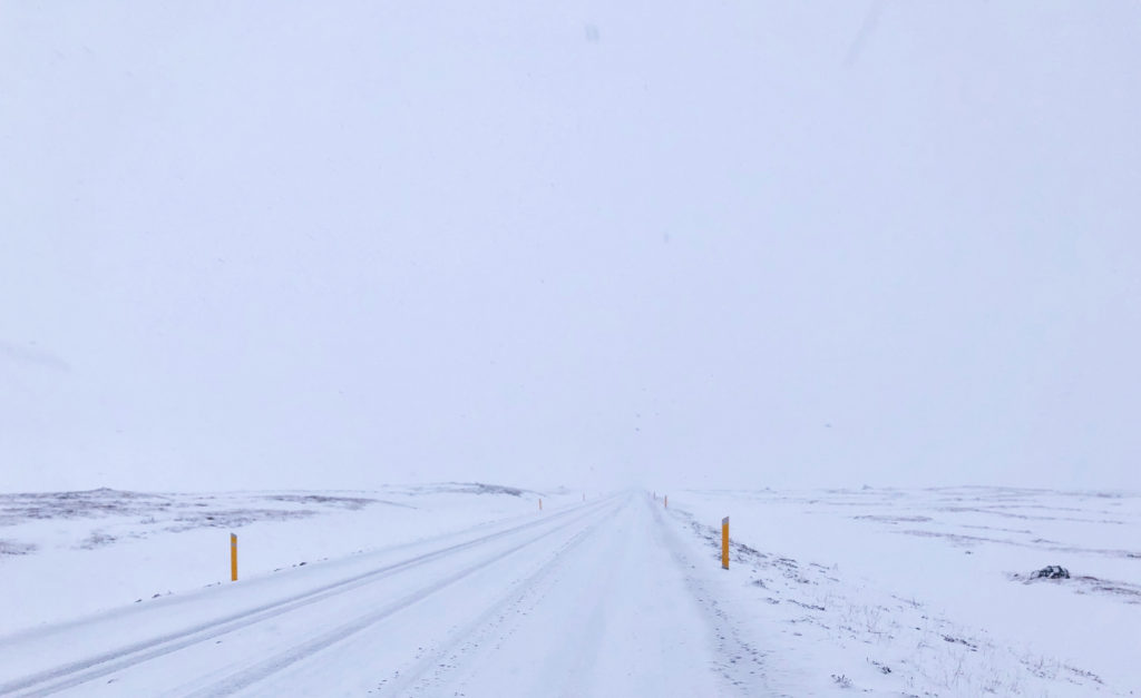 Road markers peaking out in a total white out along Iceland's Ring Road, Highway 1