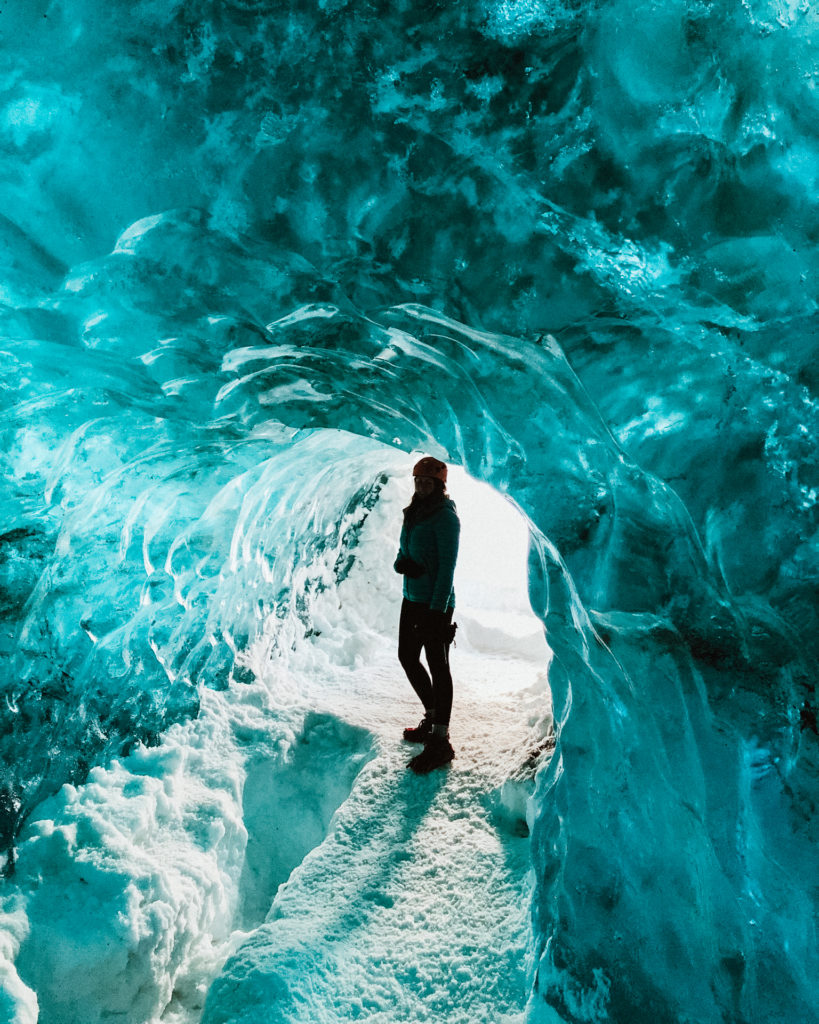 Woman silhouetted inside an ice cave on Vatnajokull Glacier, Iceland