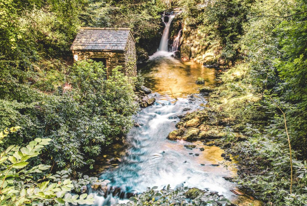 Small stone building surrounded by ferns next to Rydal Falls