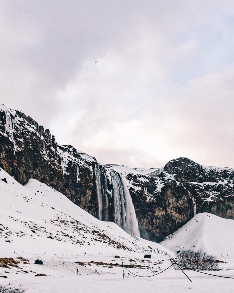 Pink skies over snowy Seljalandsfoss Waterfall