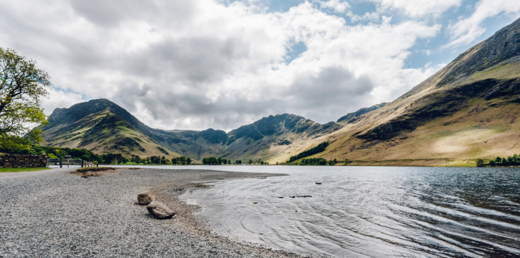 View of Haystacks across the water and pebbly edge of Buttermere