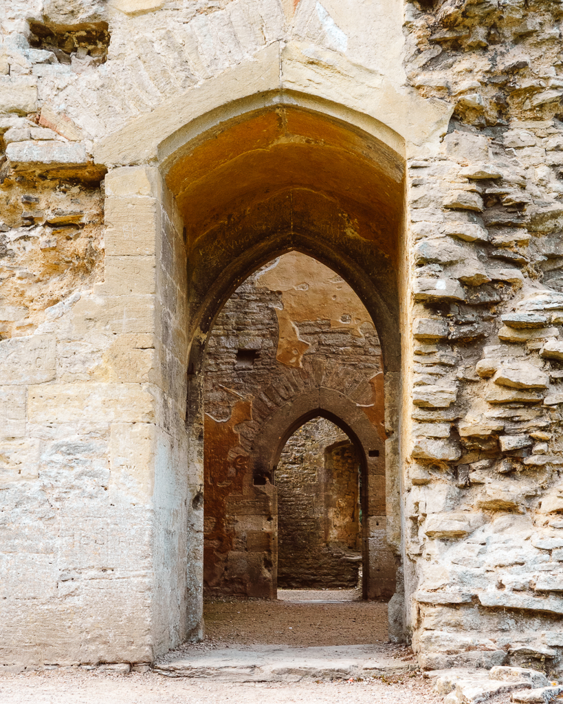 View through multiple stone archways at the ruins of Minster Lovell Hall. 