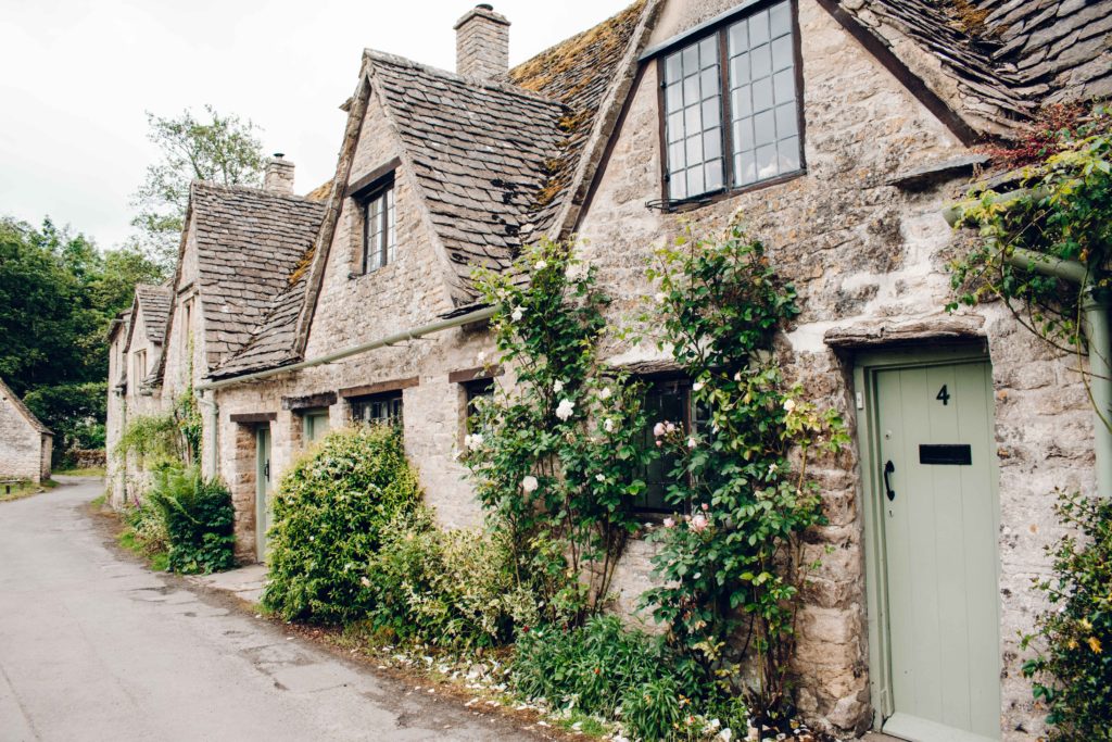 Rose covered stone cottages of Arlington Row in Bibury, The Cotswolds.
