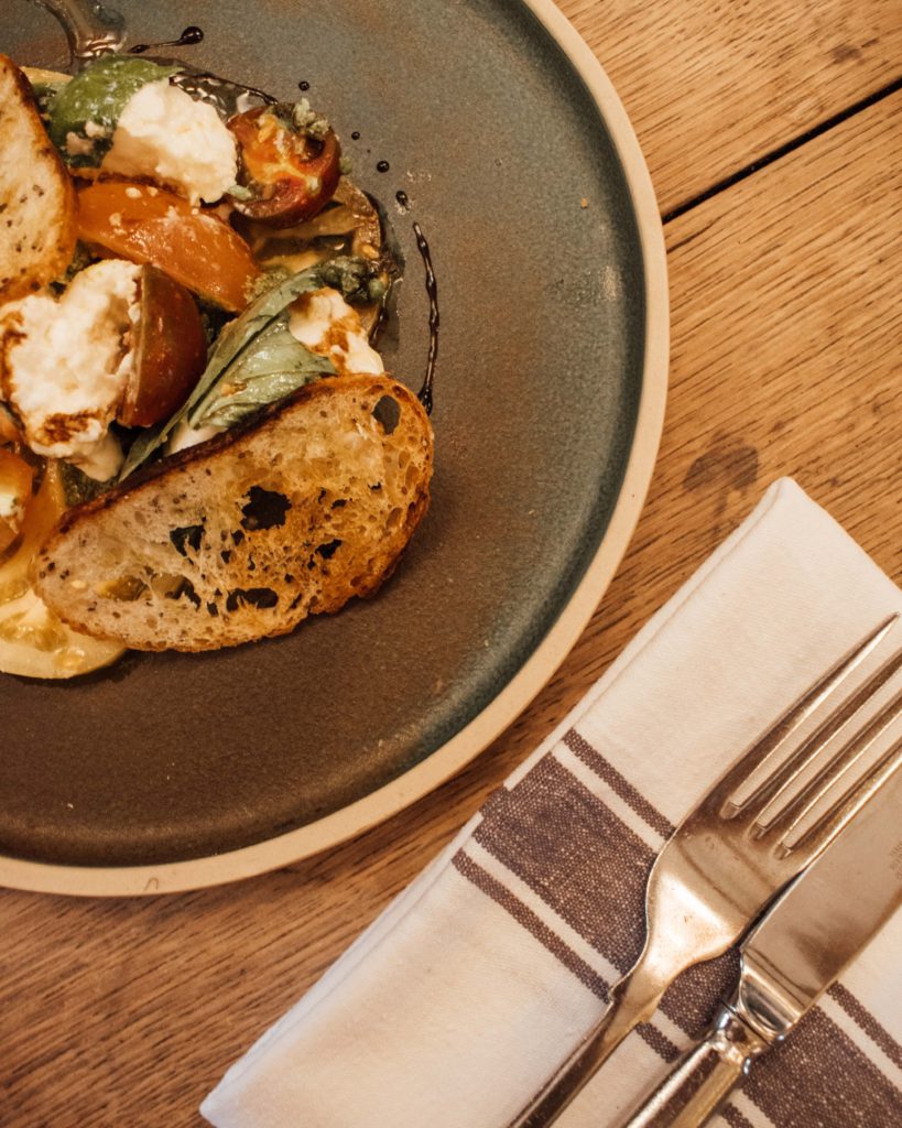 Flatlay of tomato and burrata salad at the Kingham Plough, Cotswolds.