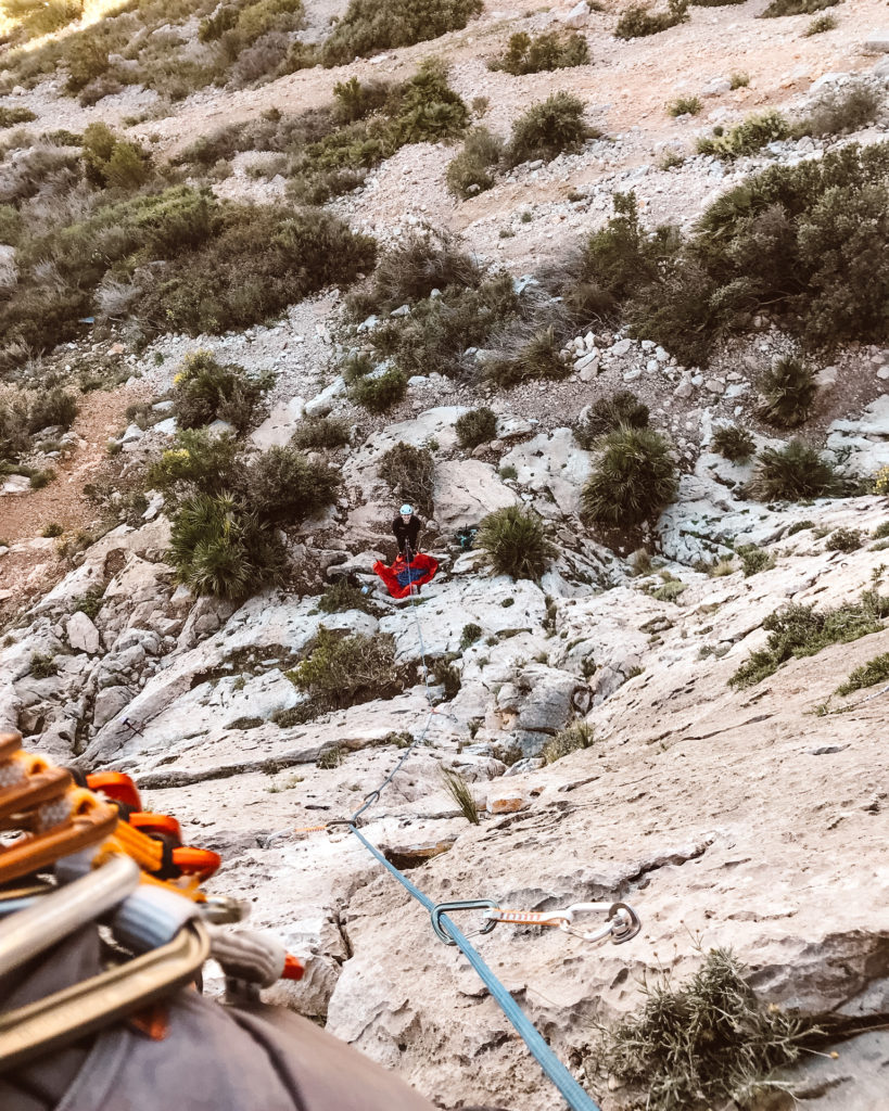 Woman belaying man on rocks at Sierra de Toix. 