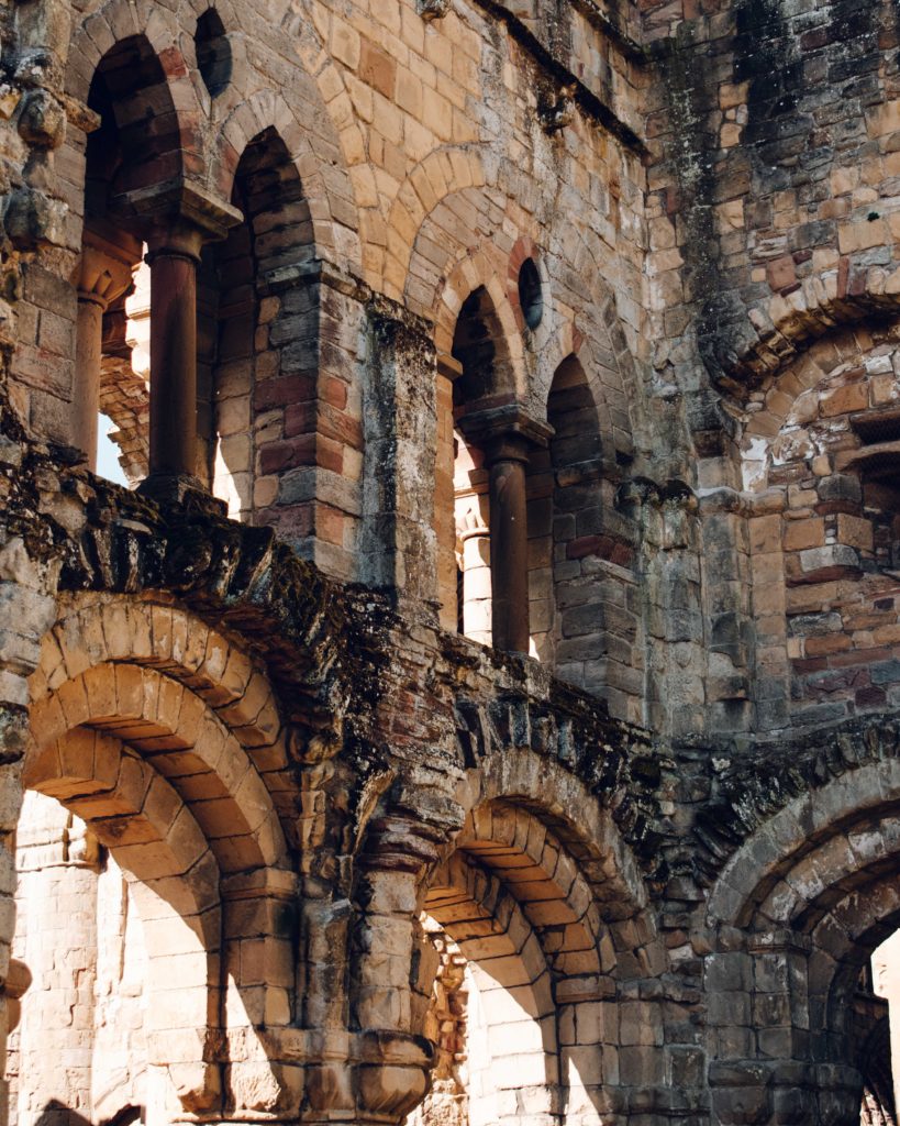 Arched stone windows in the the summer light at ruined Jedburgh Abbey