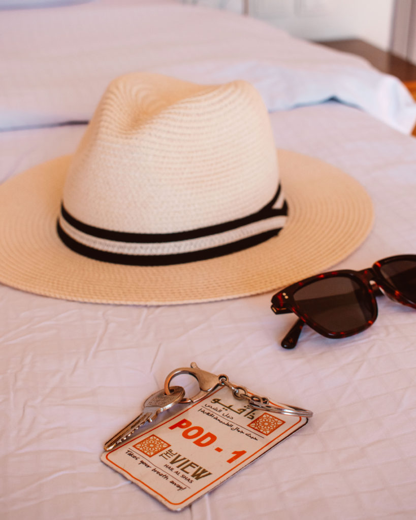 Straw Panama hat and sunglasses on a bed at The View, Jebel Shams
