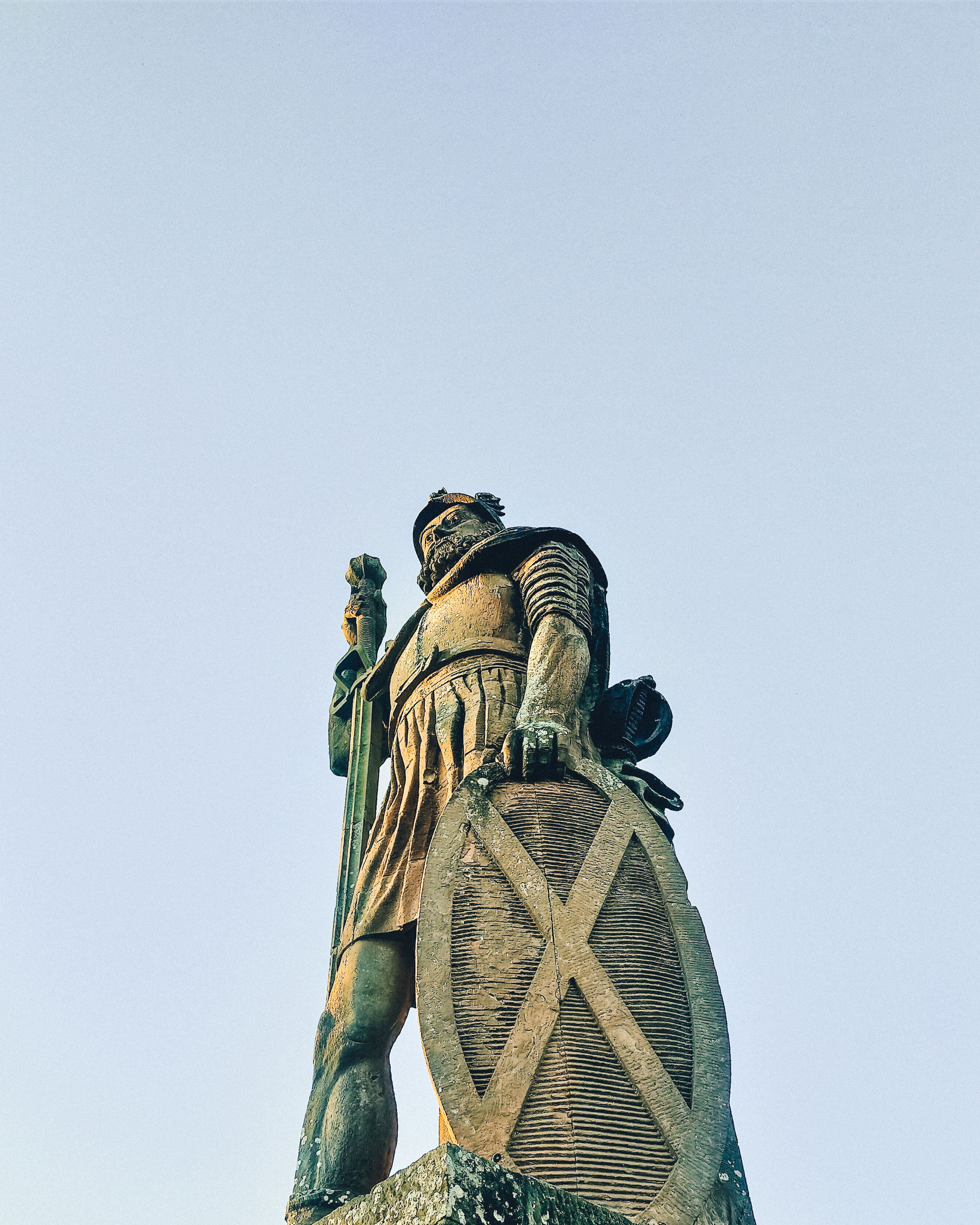 Looking upwards at a large stone statue of William Wallace in the Scottish Borders