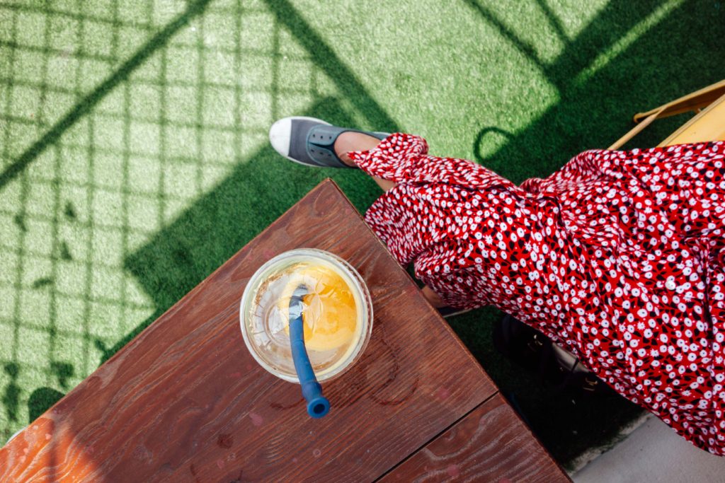 View from above of woman drinking fruit juice at Juice World, Muttrah, Muscat