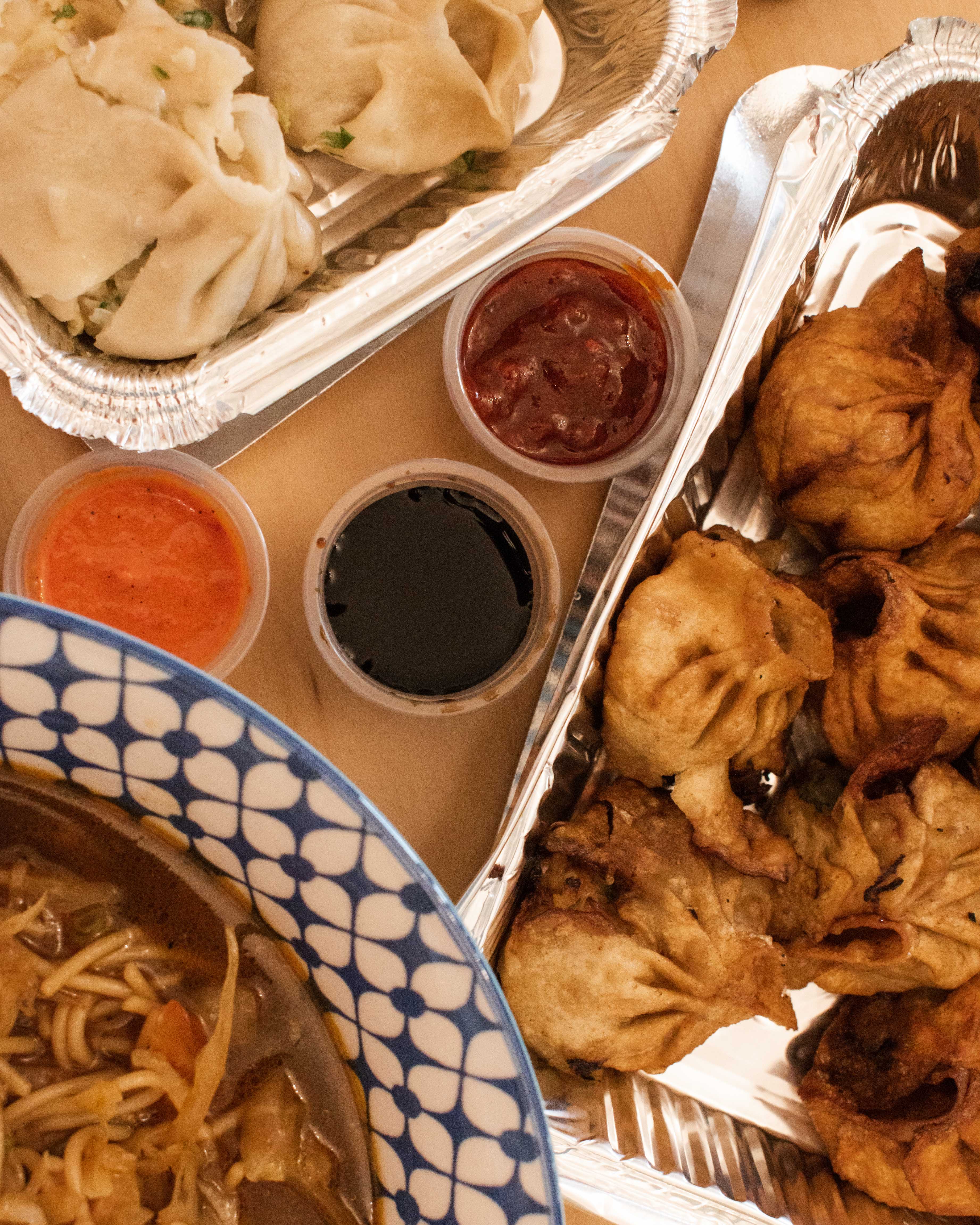 Takeaway containers with steamed and fried Momos from Al Shariq, Muscat
