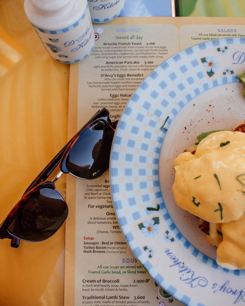 Flat lay sunglasses, menu and eggs Benedict at Darcy's Kitchen, Muscat