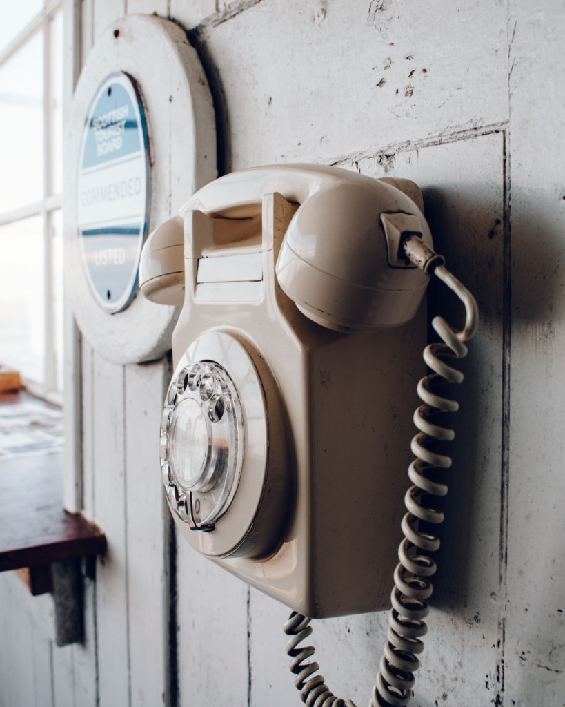 Old fashioned telephone fixed to a panelled wall