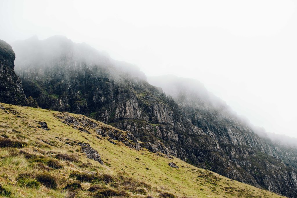 Misty clouds rolling down a rocky escarpment into the Quiraing on Skye