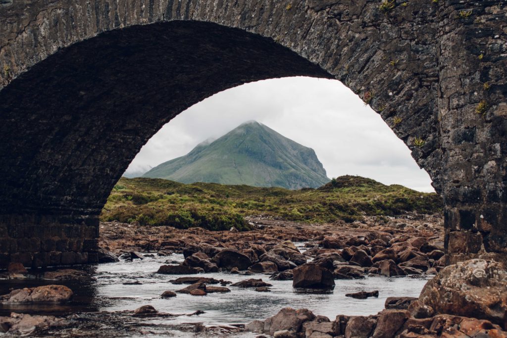 View under the stone arch of Sligachan Bridge to the mountains beyond