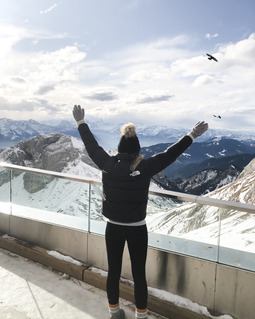 Woman in winter clothing standing on top of Mount Pilatus