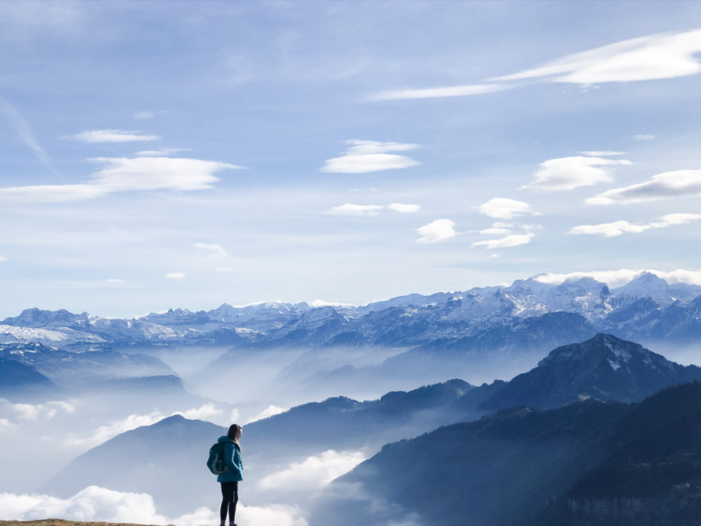 Woman shilouetted against view from Mount Rigi on sunny winter day, Lucerne