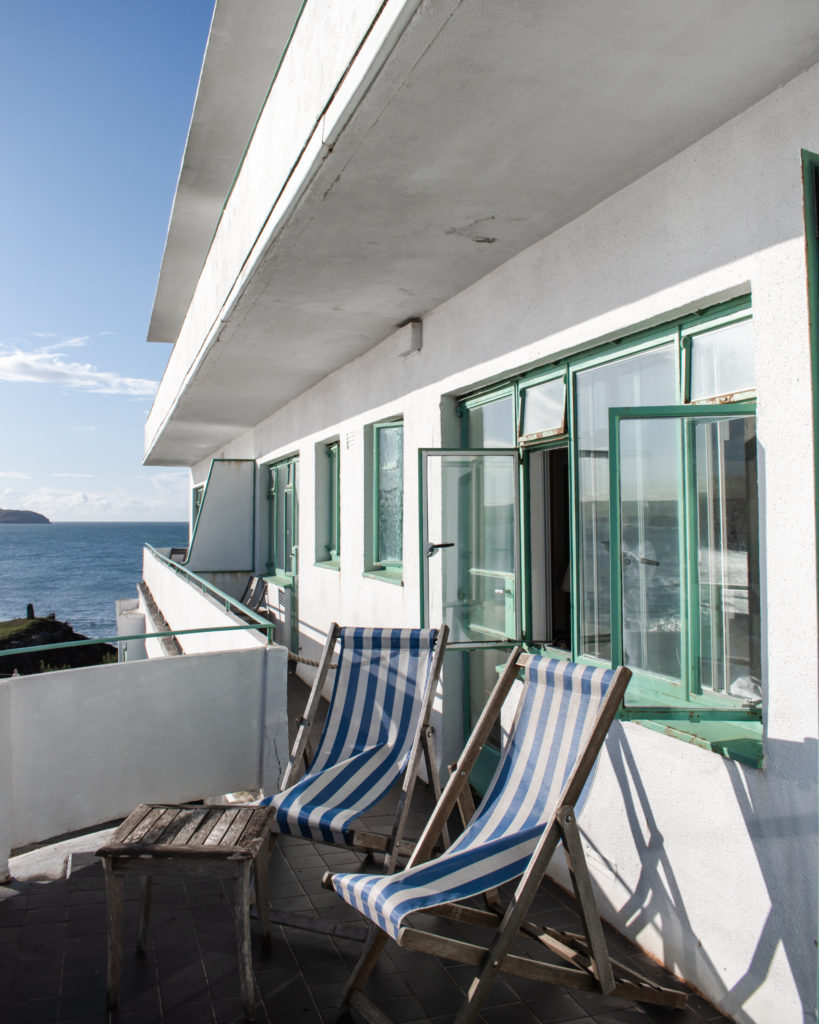Striped deck chairs on a balcony and the Art Deco exterior of Burgh Island Hotel in Devon