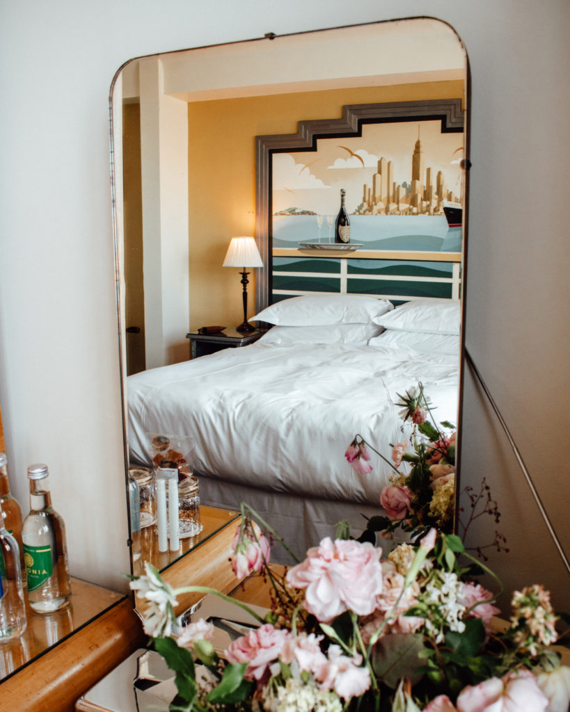 Luxury bedroom seen reflected in mirror of Burgh Island Hotel room 