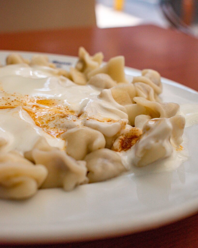 Tiny rolled Turkish dumplings, meant, covered in yoghurt and sumac