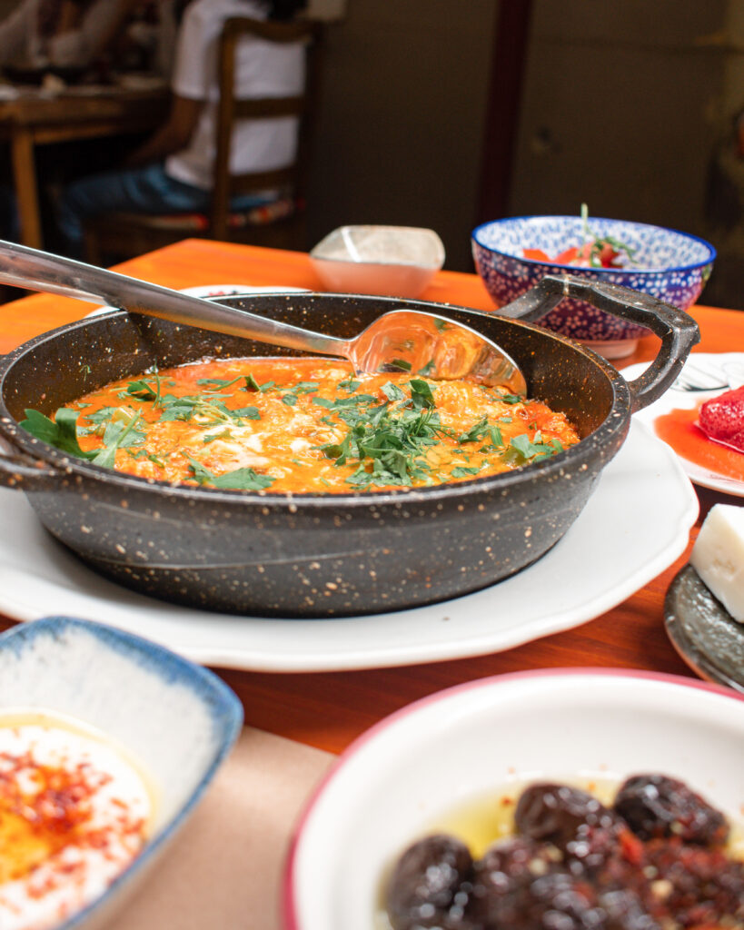 Hot dish filled with Turkish menemen scattered with herbs at Cafe Privato, Istanbul