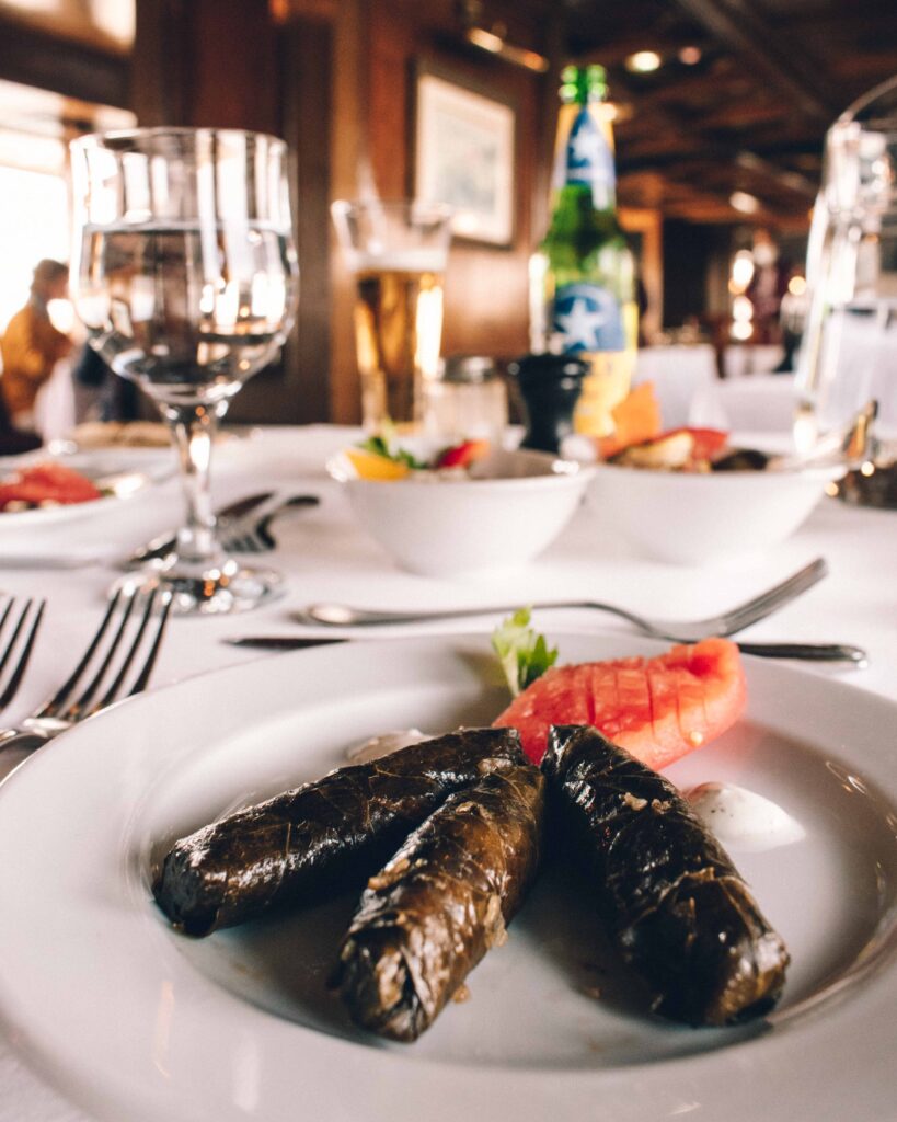 White plate with dish of wrapped vine leaves on a white linen covered table aboard a Nile Cruise