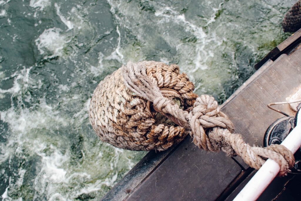 Boat rope bumper hanging off the side of a boat, above the water of the River Nile