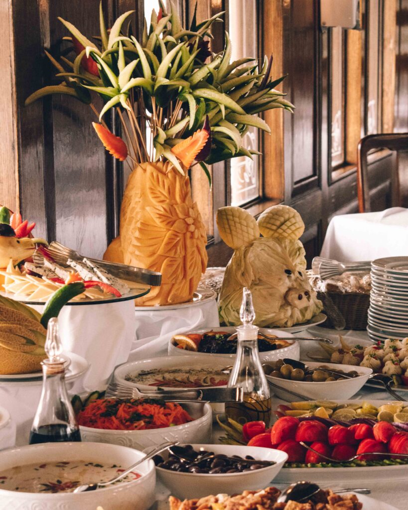 Elaborately laid buffet table, with carved fruit animals and salads